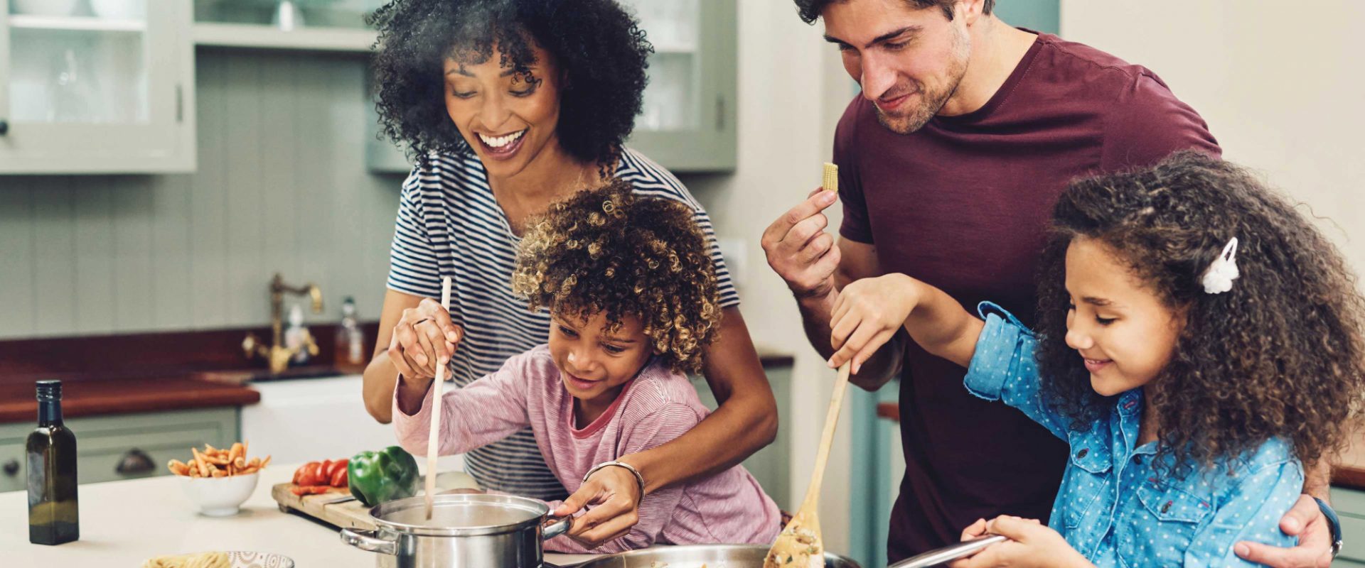 A family in their kitchen cooking dinner together.
