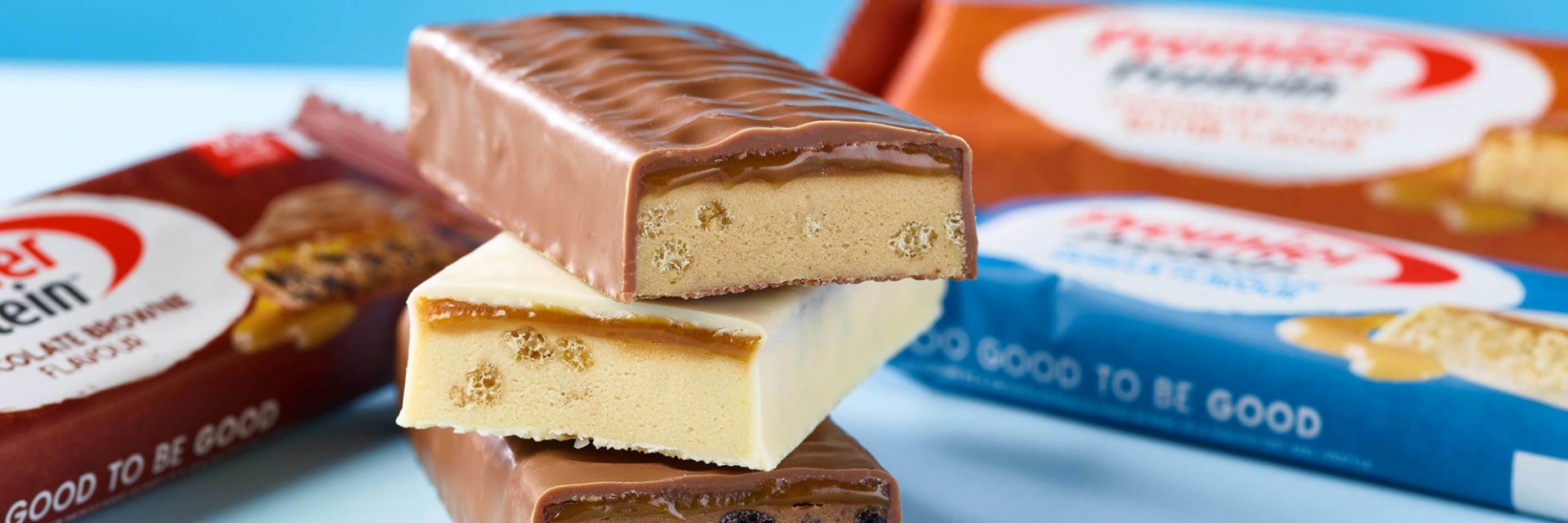 A pile of 3 Premier Protein Bars stacked on top of each other.